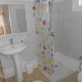 SALLE DE BAIN ; rideau de douche legerement abimé sur le bord , meuble en metal avec paniers , brosse wc, chauffage soufflant